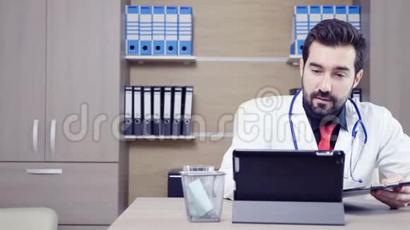 医生用平板电脑和病人通过视频会议交谈视频的预览图
