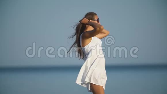 戴太阳镜的女孩在大海的背景下视频的预览图