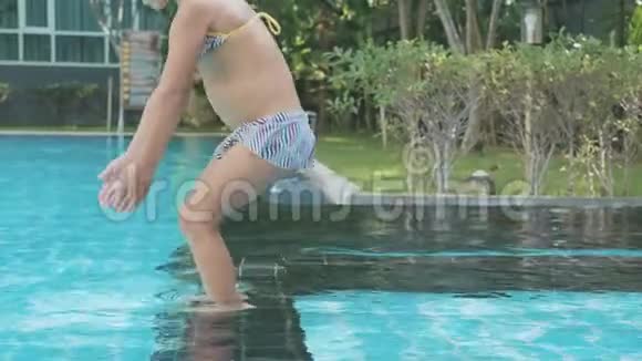 小女孩慢动作潜入室外游泳池的水中视频的预览图