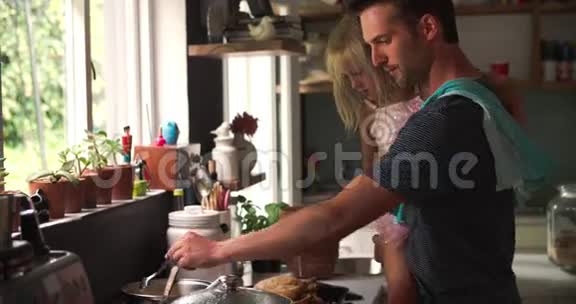 父亲在厨房里抱着女儿做饭视频的预览图