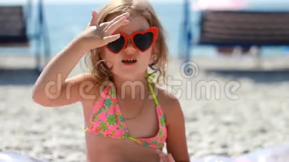 小女孩涂抹防晒霜的感觉和身体晒伤防晒霜防晒霜戴太阳镜的儿童日光浴视频的预览图