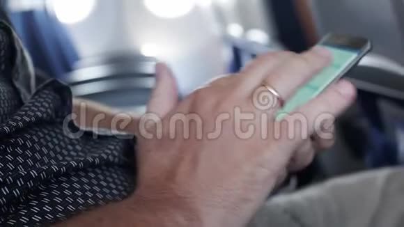 乘客在飞机上使用智能手机把他的手收起来1920x1080视频的预览图