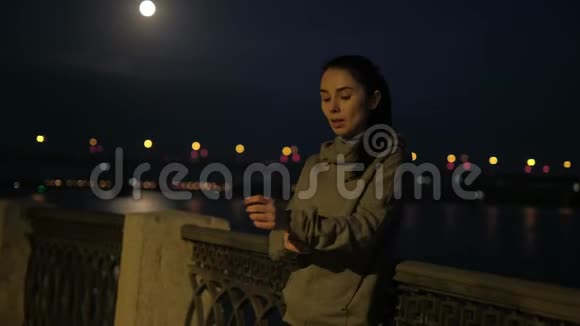 运动女孩在夜城慢跑后休息运动员心率监测器在智能手表和继续训练视频的预览图