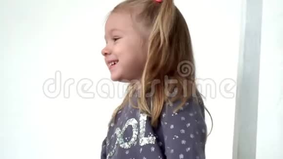那个可爱的女孩在镜头前有尾巴那个微笑的小女孩花在白色背景上视频的预览图