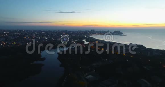 夕阳下美丽的海滨城市夜景河水流入大海视频的预览图