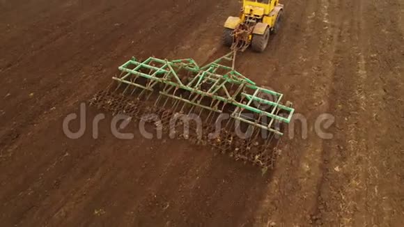 鸟瞰一辆强大的黄色拖拉机花了很大的力气在钩上进行犁耕播种冬季视频的预览图