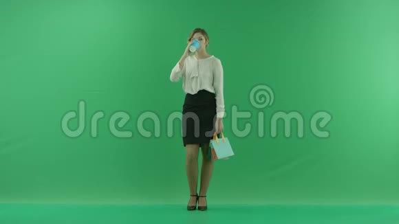 漂亮的购物女人正在用购物袋从纸杯里喝咖啡女购物者拿着购物袋视频的预览图