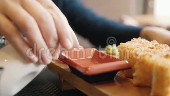 女人在吃寿司一个女人倒酱油特写视频的预览图