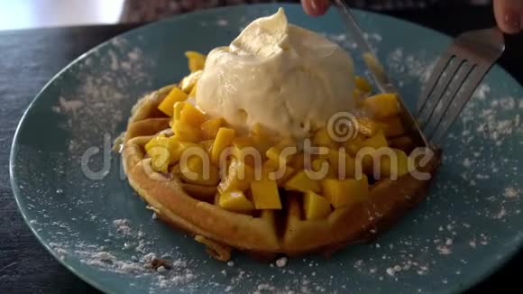 用比利时华夫饼冰淇淋和芒果吃甜点视频的预览图