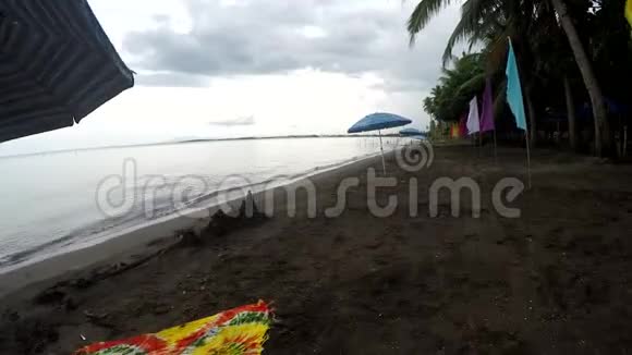 多云间阴天热带空沙滩彩旗及伞形寄生虫线视频的预览图