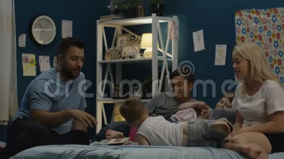 男人在床上给家人讲故事视频的预览图