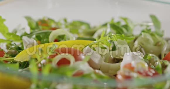橄榄油倒入一个玻璃碗里面有机蔬菜奶酪和南瓜籽沙拉特写镜头慢动作视频的预览图