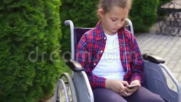 坐轮椅的残疾女孩用电话视频的预览图