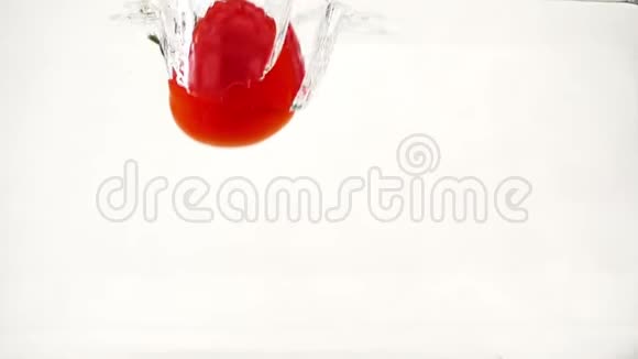 多汁的西红柿一半被浸入水中溅出水花和气泡慢动作特写视频的预览图