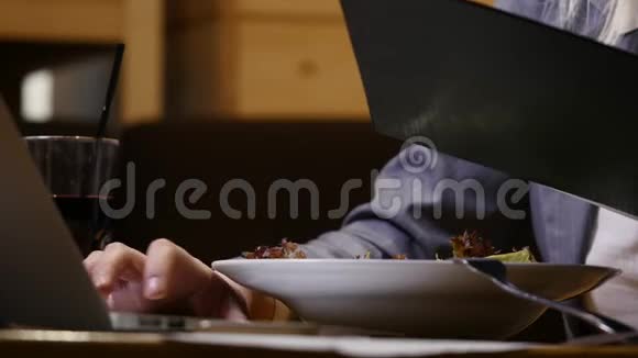 女商人的手在咖啡馆吃午餐在笔记本电脑里工作视频的预览图