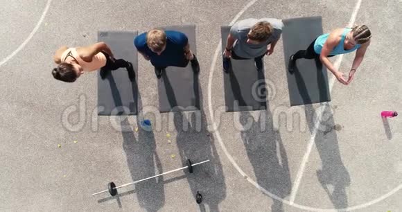 空中无人驾驶飞机拍摄的一群训练有素的男子和妇女在做运动视频的预览图