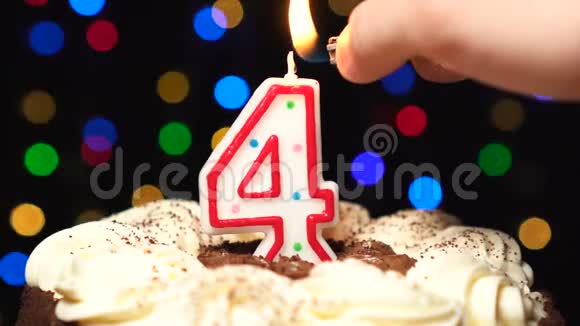 蛋糕上的4号四个生日蜡烛燃烧在最后吹灭彩色模糊背景视频的预览图
