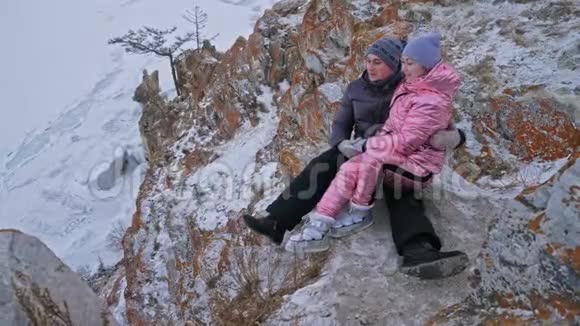 这对年轻夫妇喜欢在冬天的山顶上户外散步活跃的情侣走过冬天美丽视频的预览图