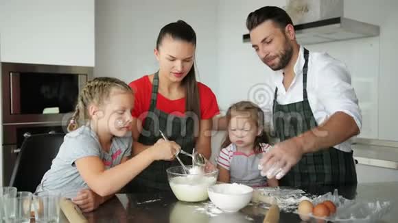 一家人一起做饭他们在厨房玩得很开心可爱的女儿和他们英俊的父母玩耍视频的预览图