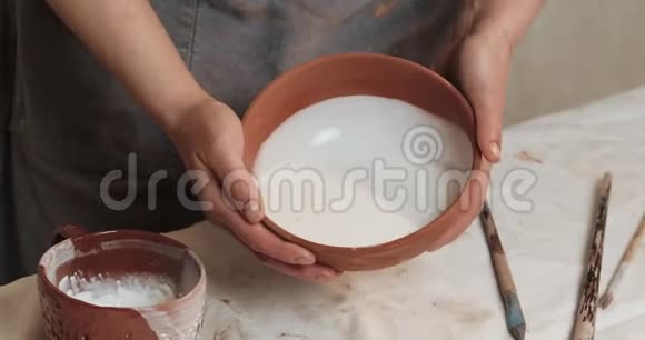 熟练的陶工釉从红泥中覆盖杯子关上门进程陶瓷车间视频的预览图