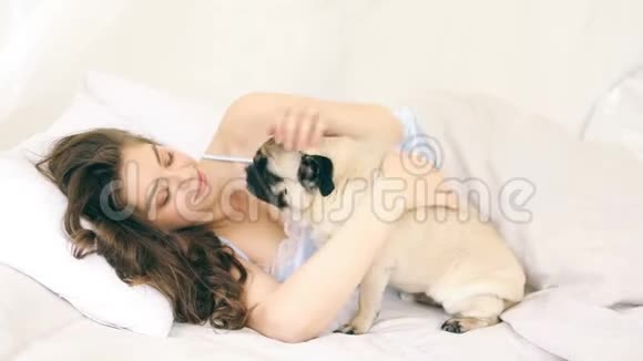 女人在床上抱着小狗录像片段视频的预览图