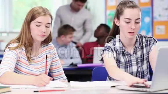 教师与两名高中女生在教室里使用笔记本电脑视频的预览图
