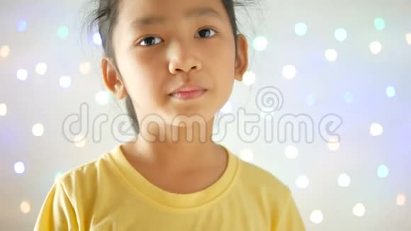 亚洲小女孩在闪光的背景下做个手势视频的预览图
