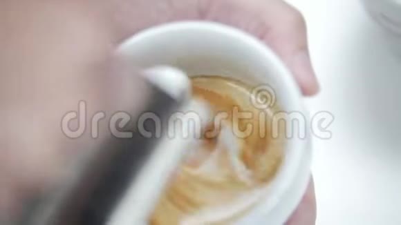 咖啡师倒一杯拿铁咖啡创造一个美丽的形象视频的预览图