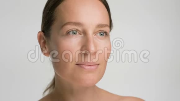 年轻女性皮肤光滑健康的特写美女肖像白色背景微笑护肤理念视频的预览图