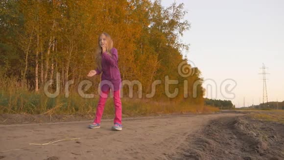 快乐的白姑娘蹦蹦跳跳的摇滚在田野的农村场景秋日落日慢点莫视频的预览图