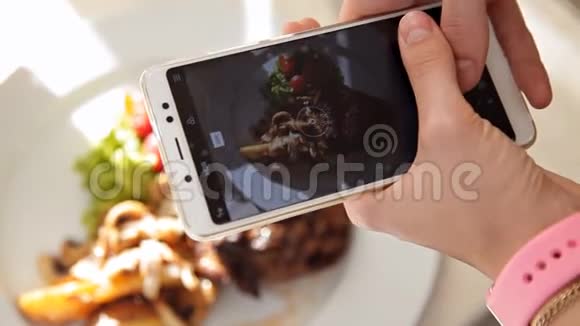 女人用智能手机拍照晚餐食物特写视频的预览图