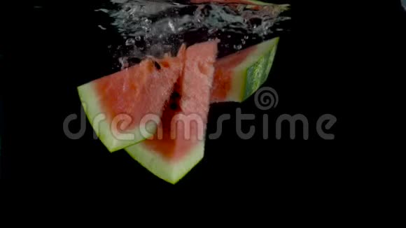 一片片西瓜落在水中漂浮黑色背景慢动作视频的预览图