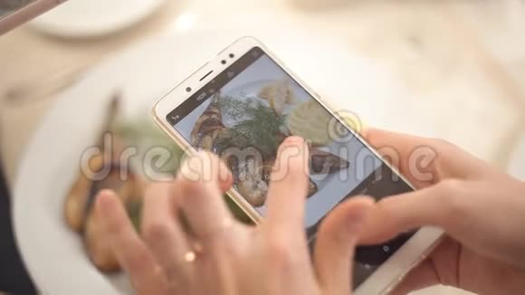 女人用智能手机拍照晚餐食物特写视频的预览图