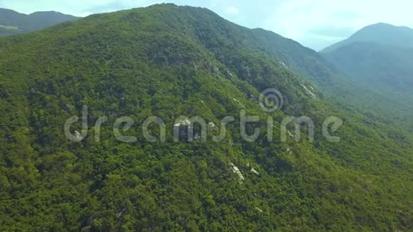 青山覆盖热带树木和大石头鸟瞰美丽的山景从空中飞行无人机视频的预览图