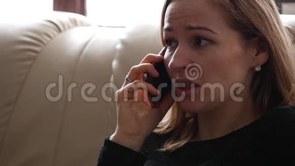 年轻女人在智能手机上和别人说话时感到悲伤和哭泣慢动作视频的预览图
