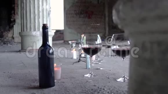 灰色背景上有两杯蜡烛酒瓶录像带着酒和蜡烛的浪漫静物视频的预览图