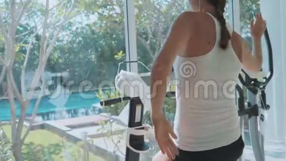 在健身馆里骑着静止的自行车慢动作的特写女性脚视频的预览图