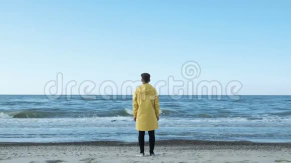 穿雨衣的人的后景和海边的慢车景视频的预览图