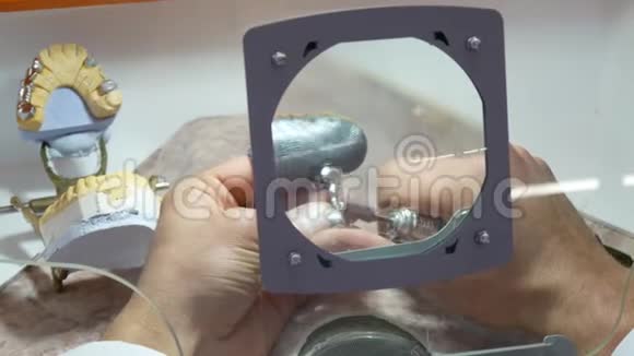 牙科技师用放大镜把金属框架磨碎视频的预览图