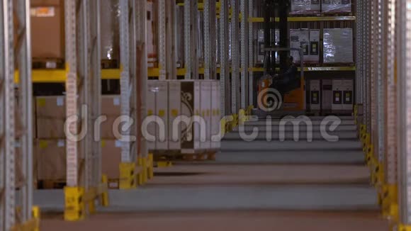叉车在仓库的两排之间行驶一个人在仓库里驾驶叉车视频的预览图