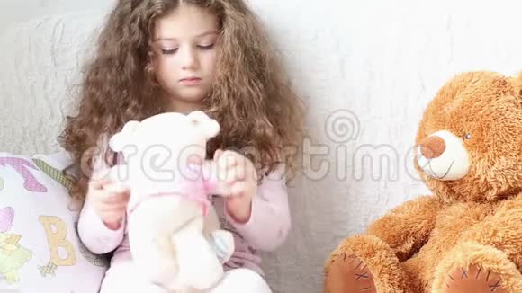 小女孩在沙发上玩玩具熊视频的预览图