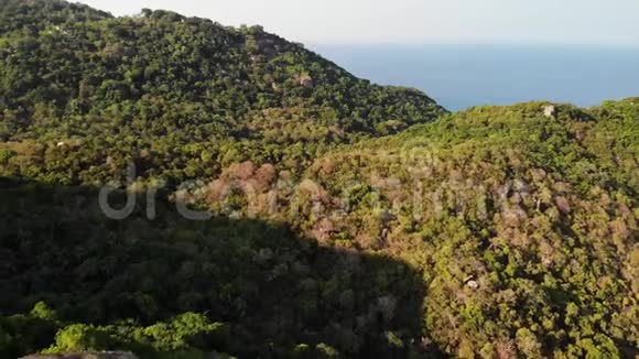 热带岛屿的丛林和山脉科岛火山岩地形上绿色丛林和巨大巨石的无人视野视频的预览图