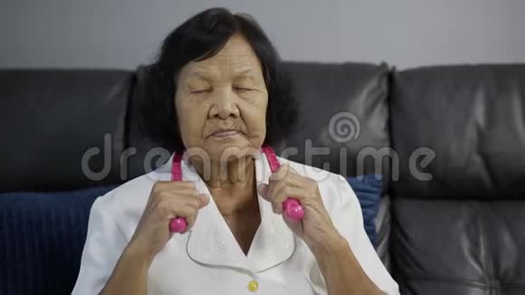 患有颈部疼痛和按摩辅助工具按摩的老年妇女视频的预览图