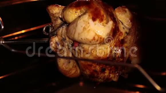在烤炉里烤整只鸡烤鸡在烤架下旋转视频的预览图