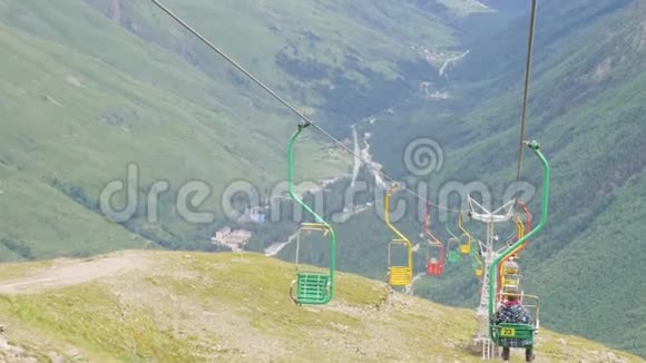 夏天在一个空的滑雪场坐电梯参观山谷和冰川的游客视频的预览图