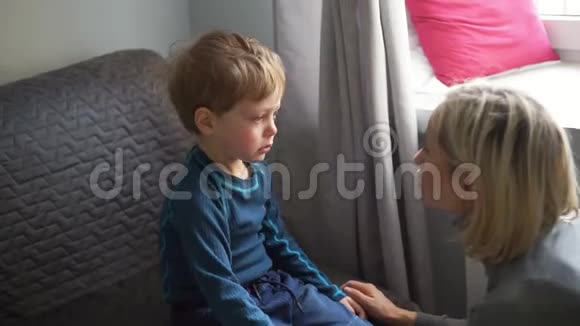 心烦意乱的小男孩拥抱他的母亲在家里哭视频的预览图