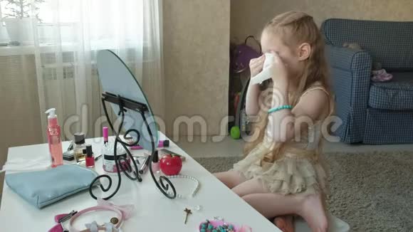 红头发的小女孩照镜子用湿巾清洁面部皮肤化妆面部时尚风格视频的预览图