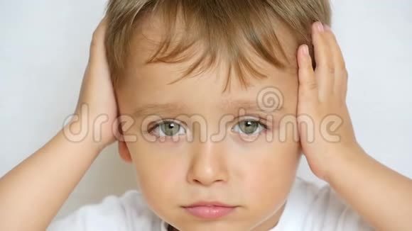 一个小孩的特写镜头若有所思地看着镜头双手抱在脑后闭上耳朵孩子视频的预览图