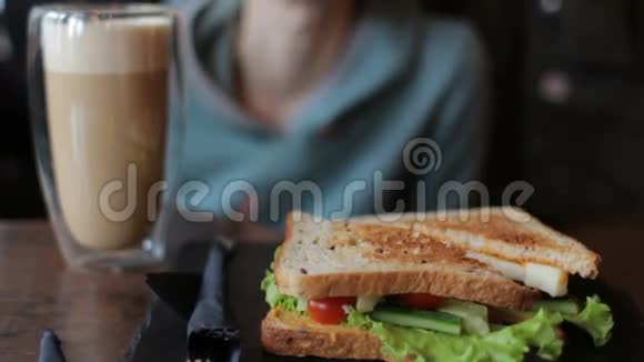 带蔬菜的美味三明治女人喝咖啡在咖啡馆吃饭视频的预览图