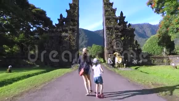 母亲和女儿进入传统的巴厘岛大门视频的预览图